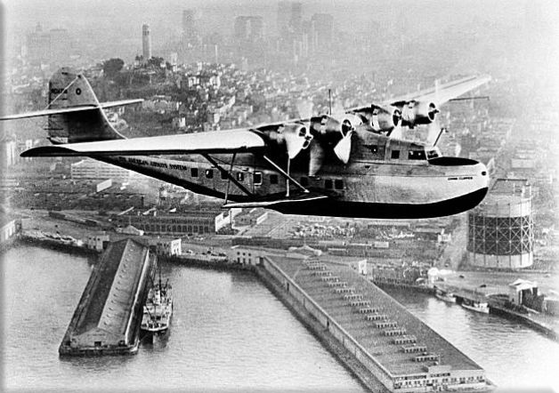Pan American Airways Martin M-130 flying boat, the China Clipper, leaves San Francisco Bay for Manila carrying the first United States trans-Pacific air mail on Nov. 22, 1935. In the background is Coit Tower and the San Francisco skyline, credit AP / San Francisco Chronicle