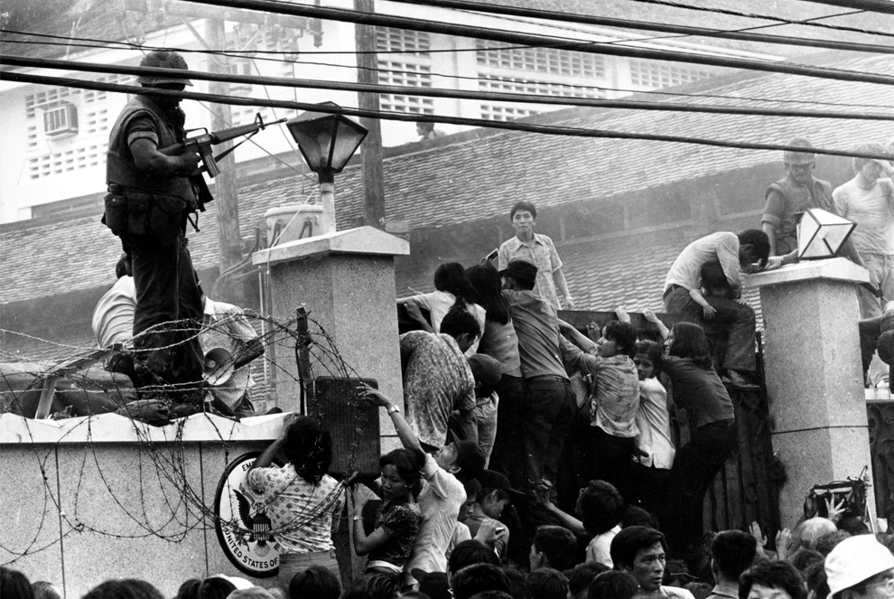 Vietnam War: Mobs of Vietnamese people scale the wall of the U.S. Embassy in Saigon, Vietnam, trying to get to the helicopter pickup zone, just before the end of the Vietnam War on April 29, 1975. Neal Ulevich, AP