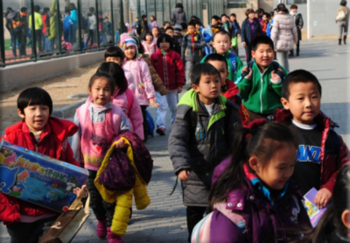 Beijing students leave their elementary school at the end of classes in this March 13, 2012 file photo. At the Chenpeng village primary school in Xinyang in Henan province, a man is suspected of stabbing one elderly woman and 22 children. Mark Ralson, AFP / Getty Images